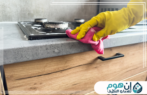 تنظيف شقق مفروشة بالدمام 0559016158 شركة إين هوم للتنظيف تنظيف سطح المطبخ بجوار موقد الغاز باستخدام قطعة قماش وقفازات واقية.
